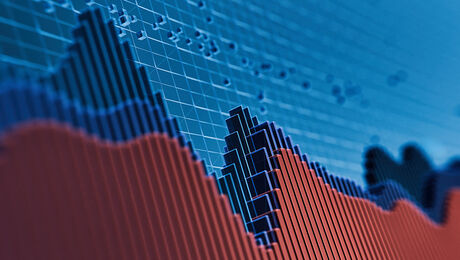 A close-up view of a colorful bar graph displaying fluctuating data trends in blue and red against a grid background