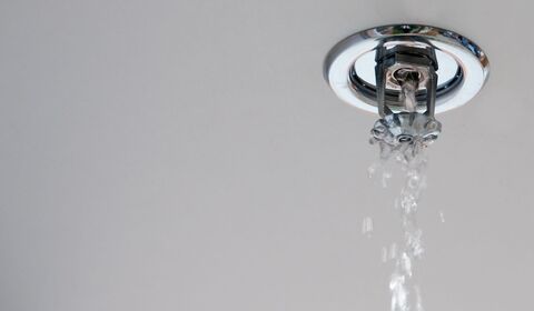 Water flowing from a damaged ceiling fire sprinkler head inside a residential building