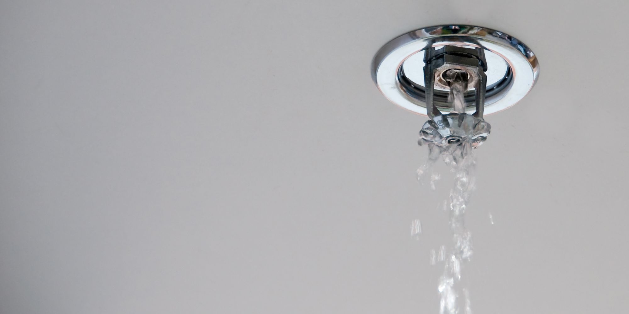Water flowing from a damaged ceiling fire sprinkler head inside a residential building