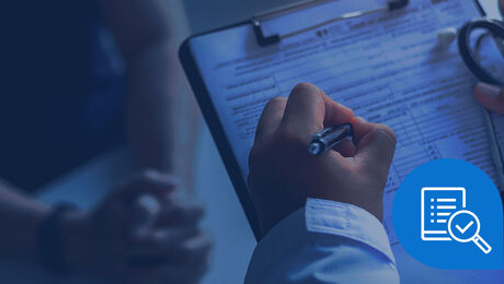 A hand holding a pen fills out a clipboard with a form, while another person's hands rest in the background