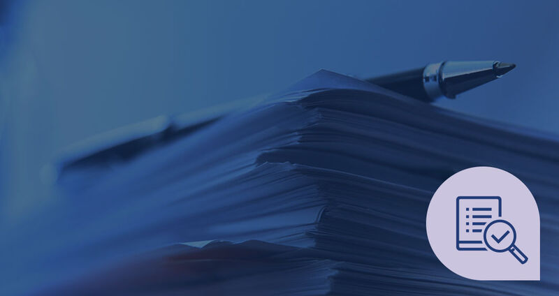 A stack of papers with a pen on top, accompanied by a magnifying glass icon on the bottom right